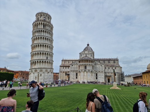 Schiefer Turm von Pisa neben der Kathedrale Schiefer Turm von Pisa neben der Kathedrale, umgeben von Touristen und Rasenfläche.